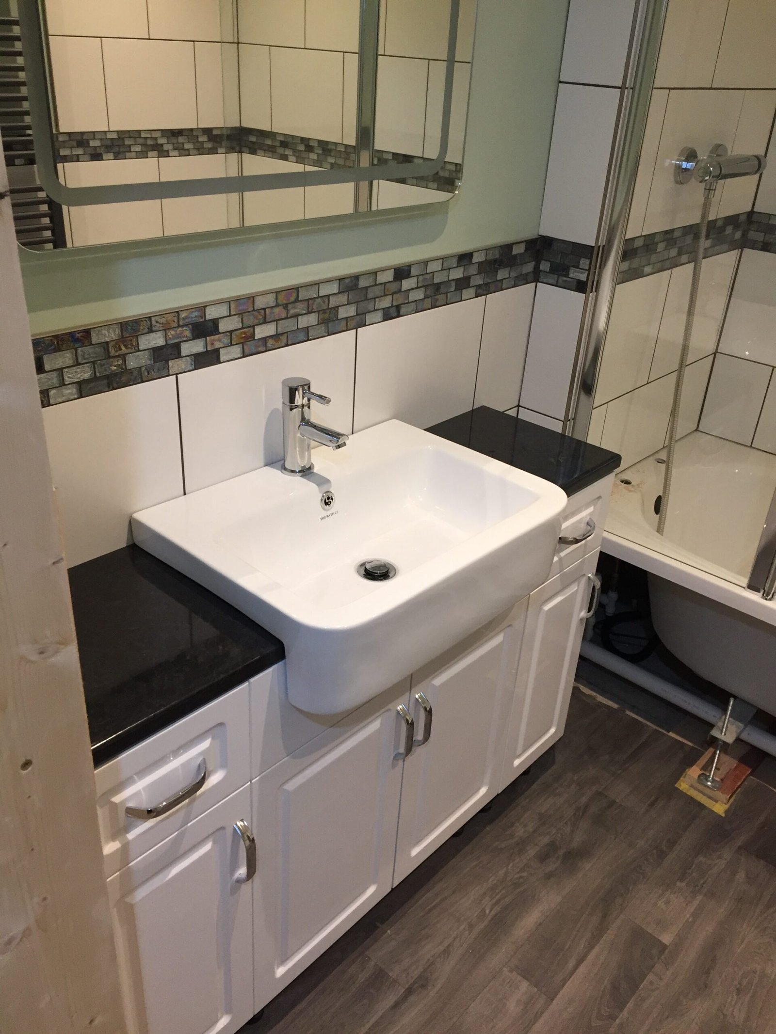 Bathroom installation with fitted vanity unit and tiled shower area in Ipswich